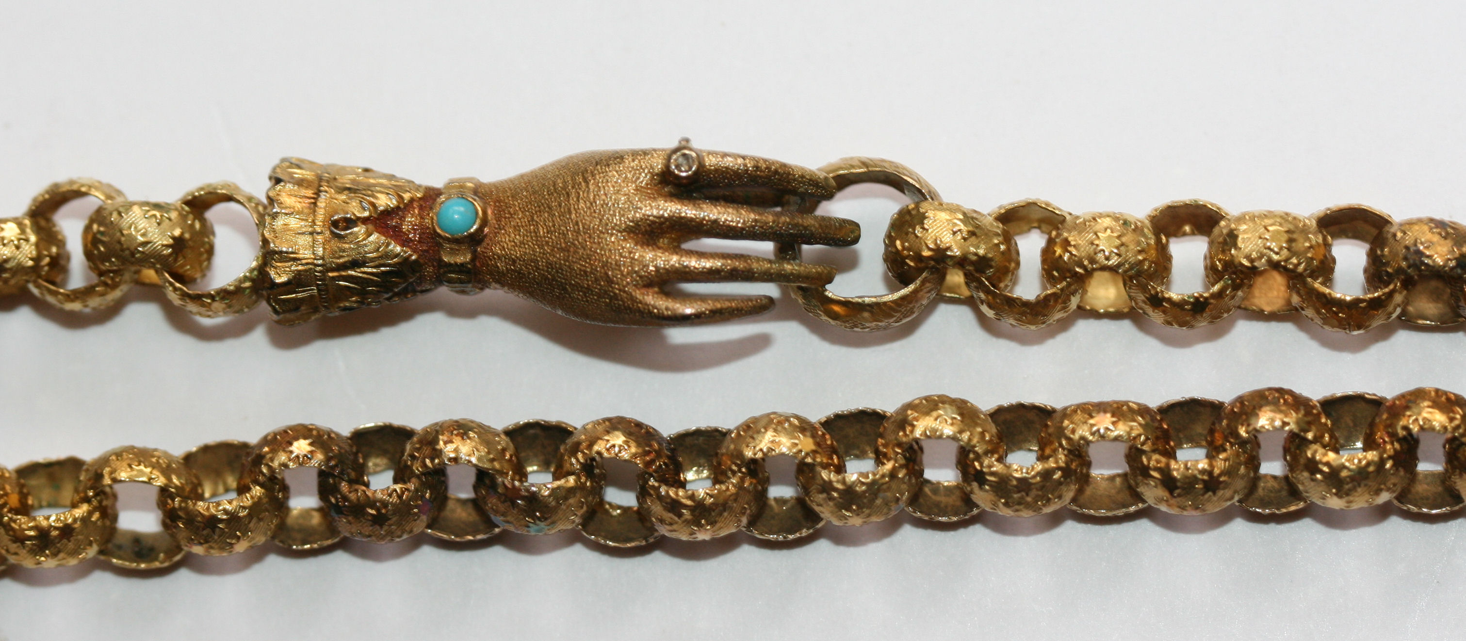 A Georgian gold chain with gem set hand form clasp