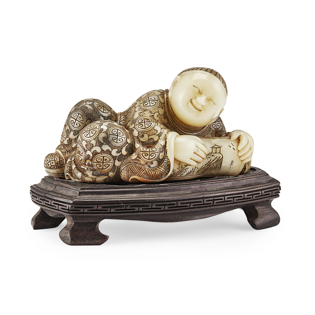 SOAPSTONE CARVING OF A RECLINING BOY