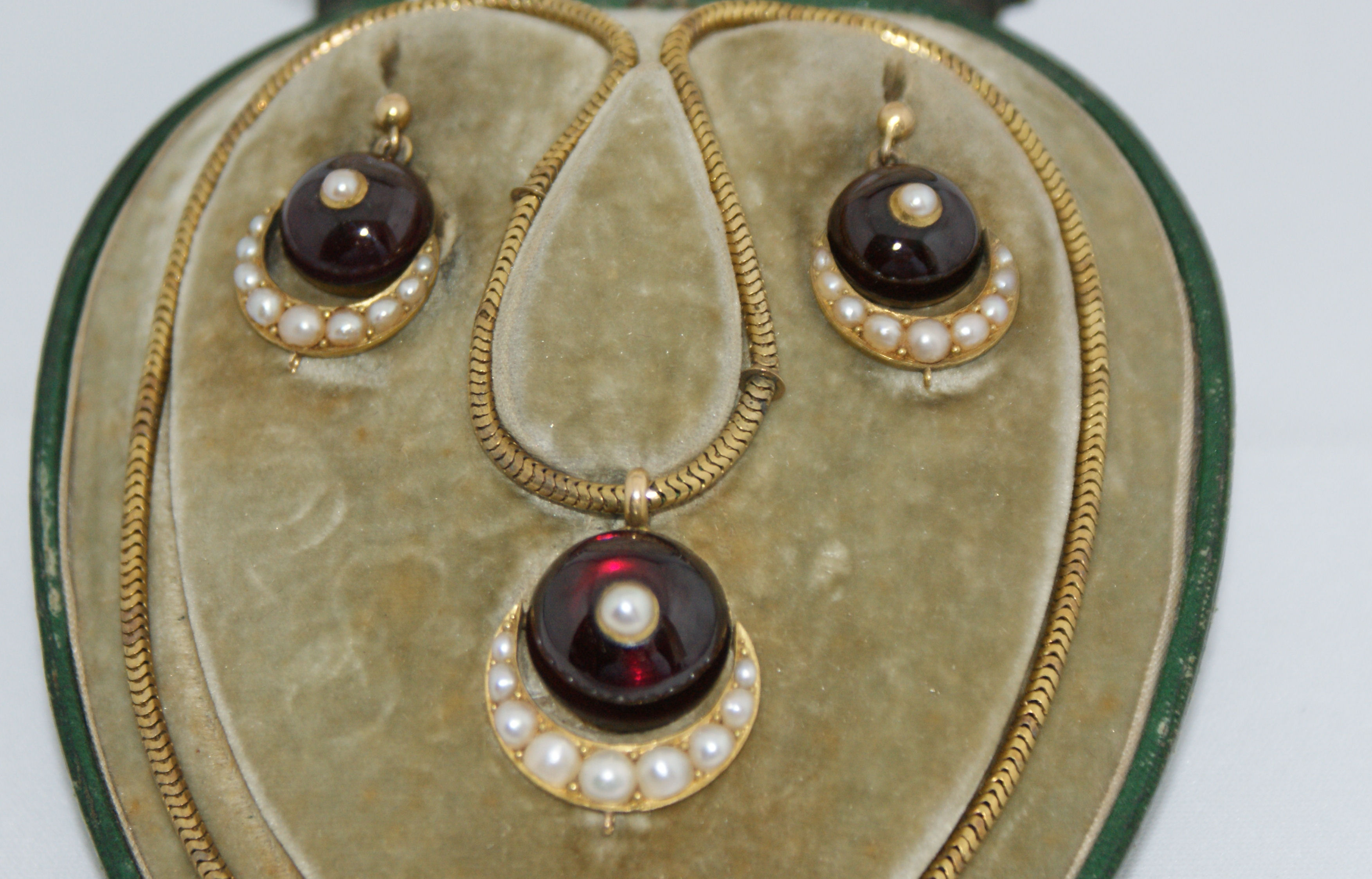 A cased Victorian garnet and pearl set demi parure