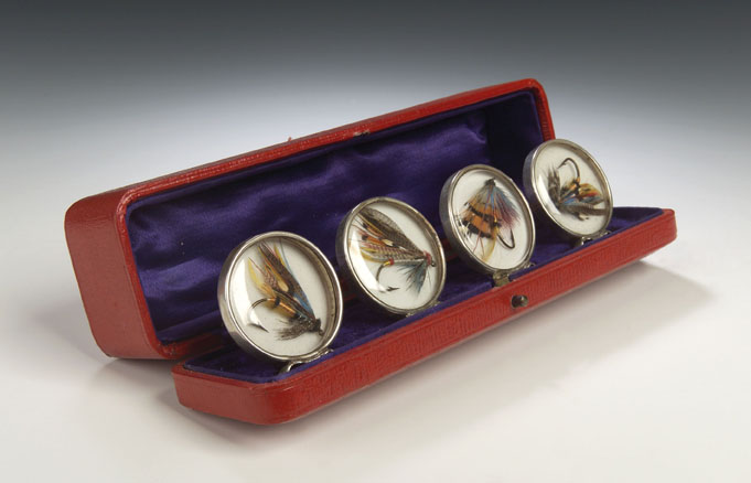 A set of four silver menu holders,