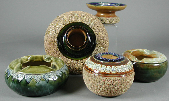 A collection of eleven Royal Doulton ashtrays and matchstands