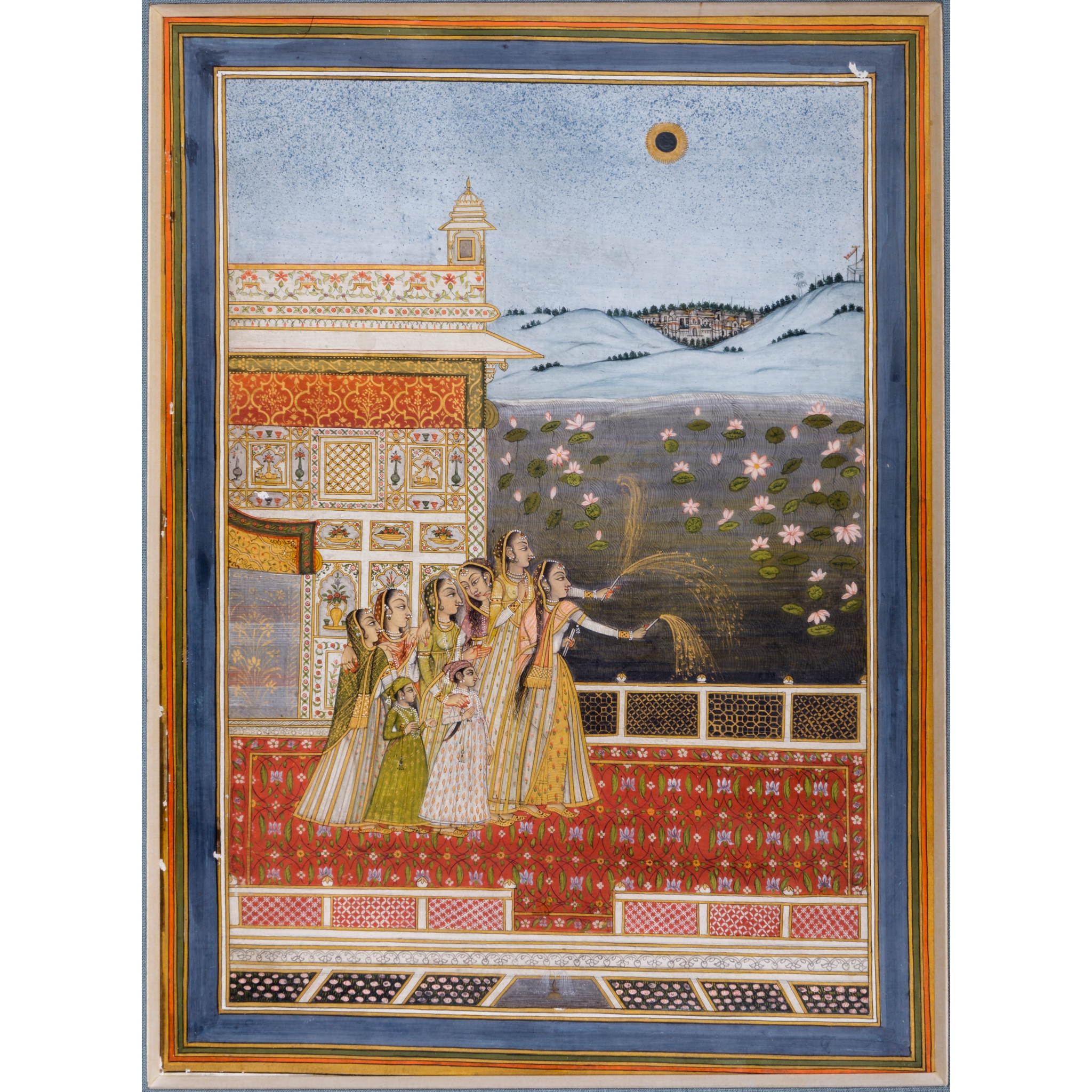 DIVALI CELEBRATIONS AT NIGHT, LADIES HOLDING FIREWORKS ON A PALACE TERRACE BY A LAKE