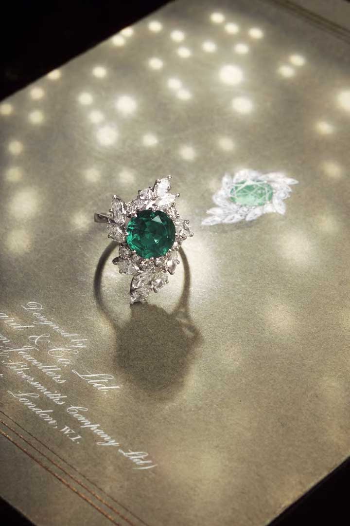 Garrard & Co. Ltd - an 18ct white gold mounted synthetic emerald and diamond cluster ring,