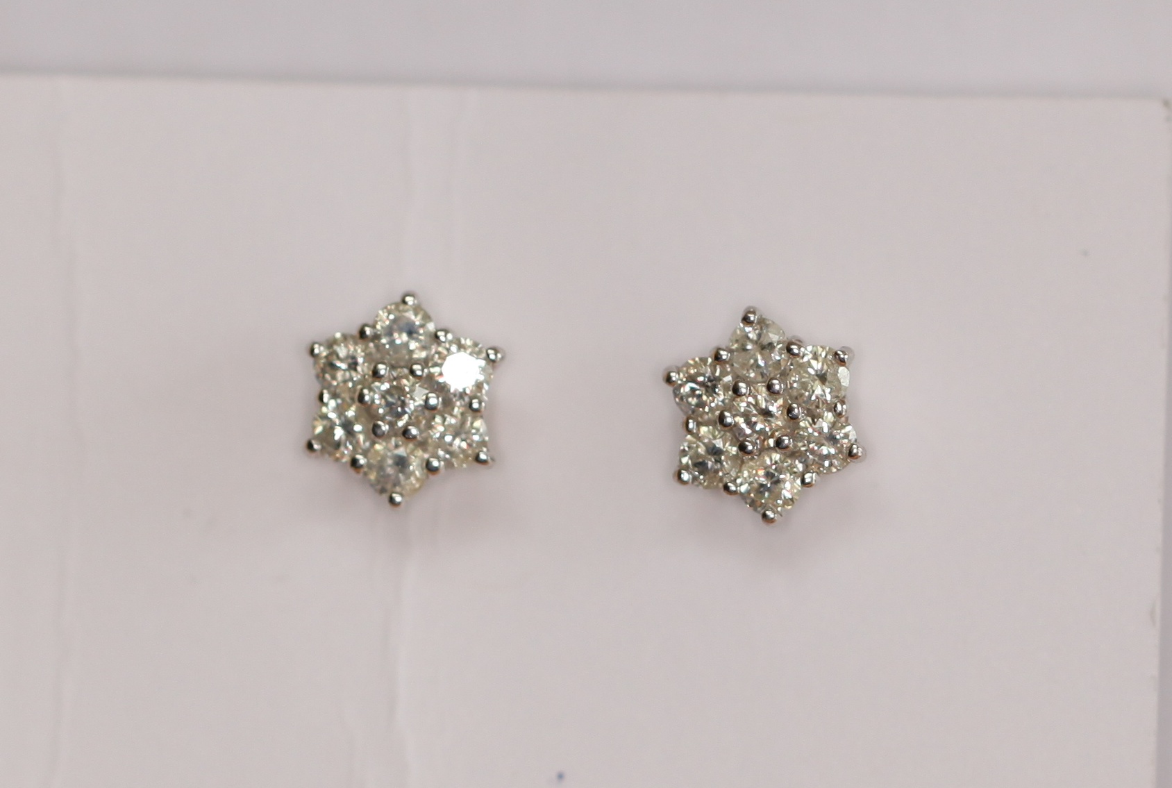 A pair of 18ct gold mounted diamond floral cluster earrings