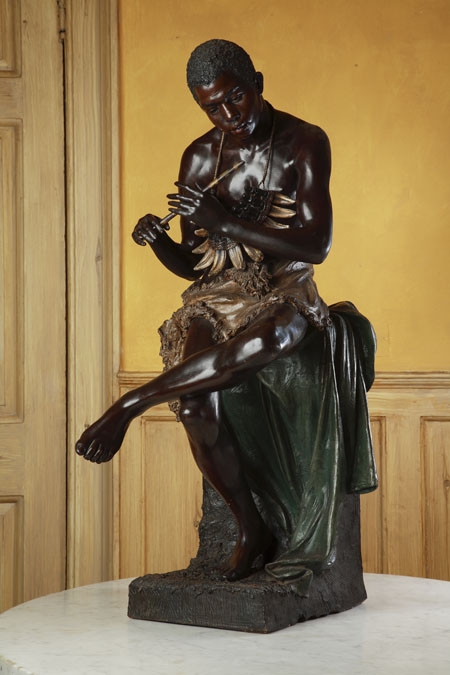 A late 19th/early 20th century Austrian painted terracotta figure of a seated Nubian by Goldscheider