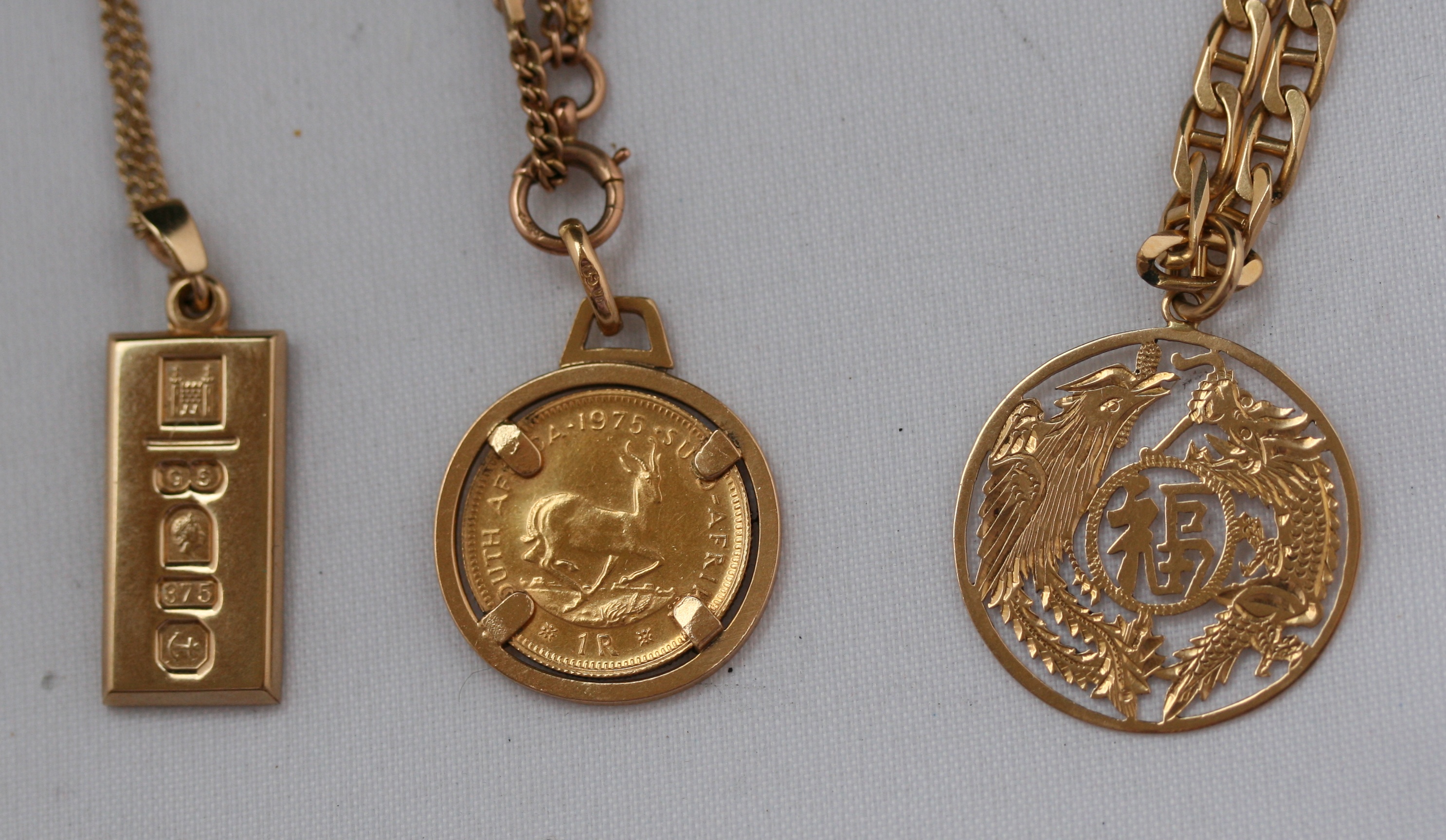 A group of three gold necklaces and pendants