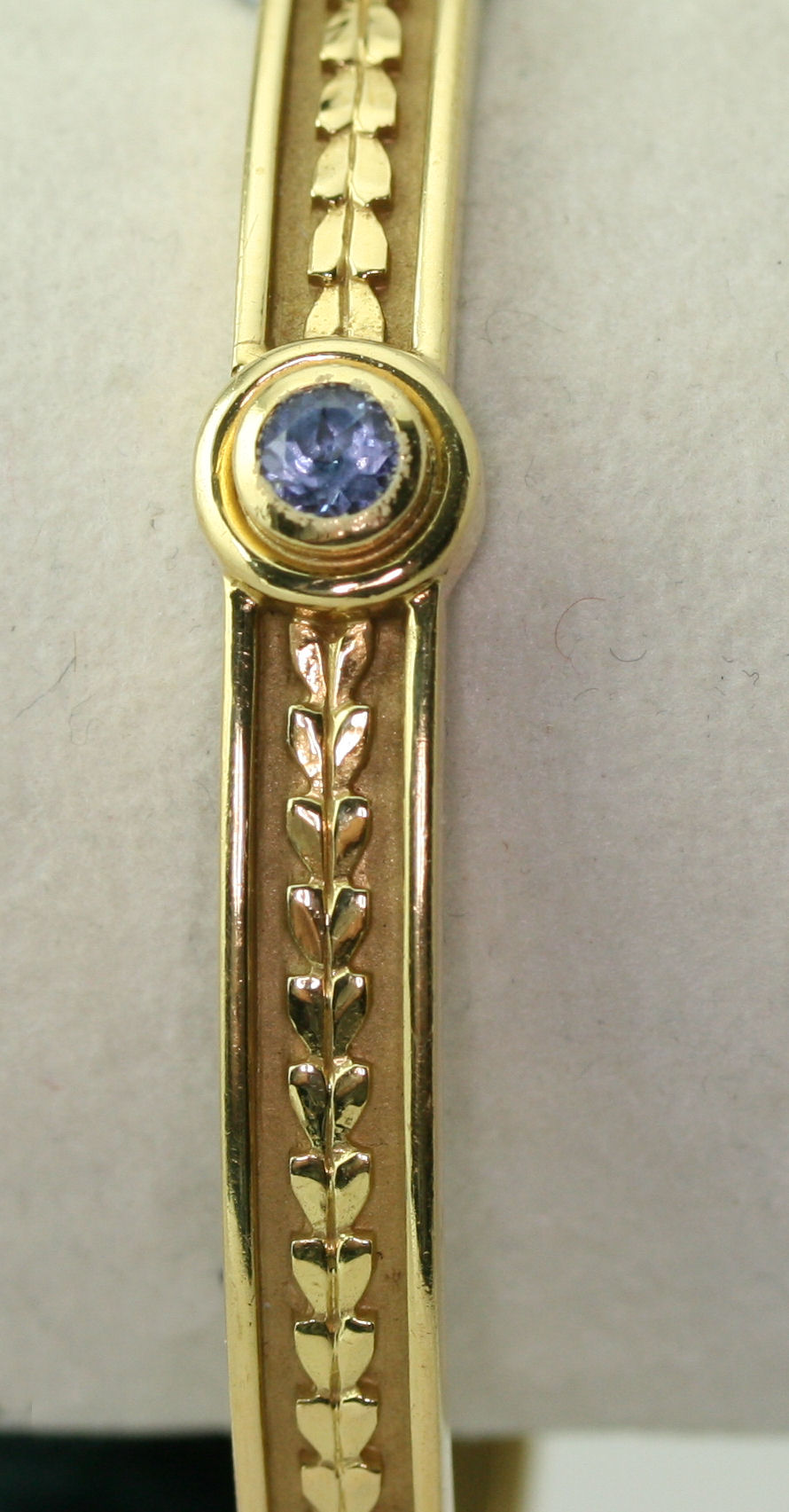 THEO FENNELL - a contemporary 18ct gold mounted Tanzanite set bangle