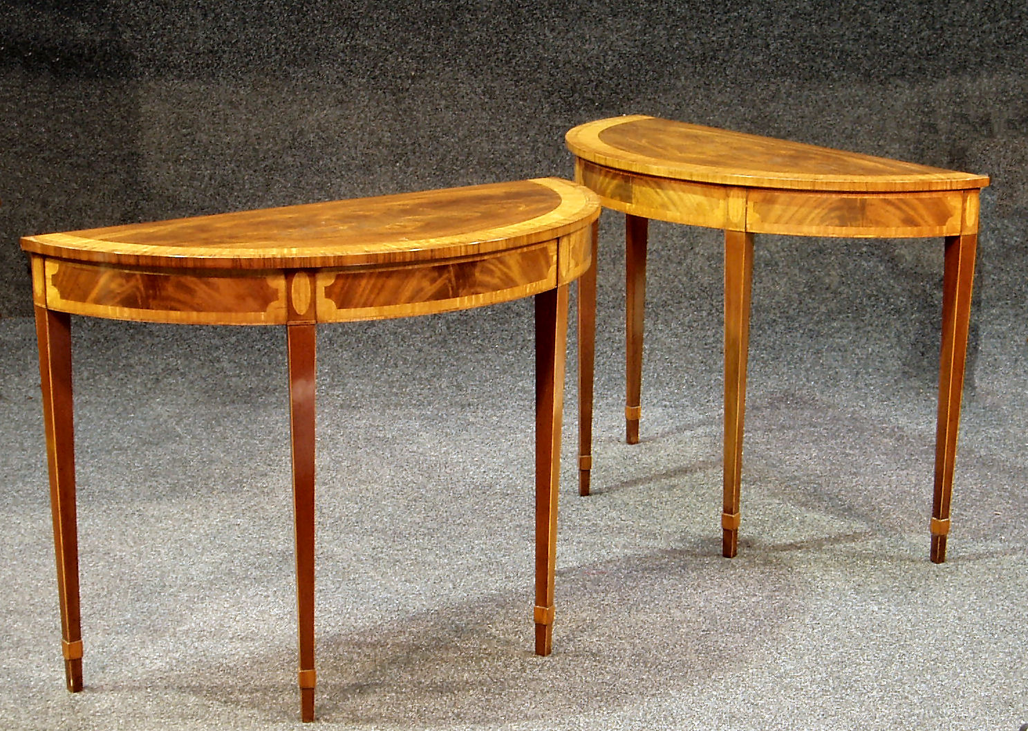 A pair of Regency style mahogany demi-lune tables