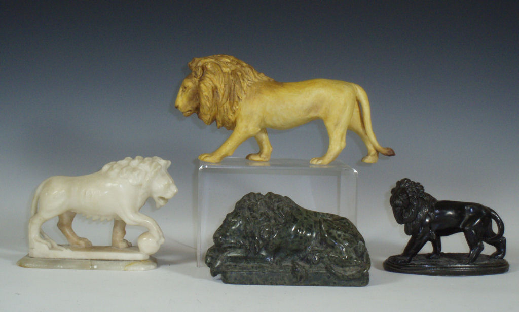 A group of four various lion figurines