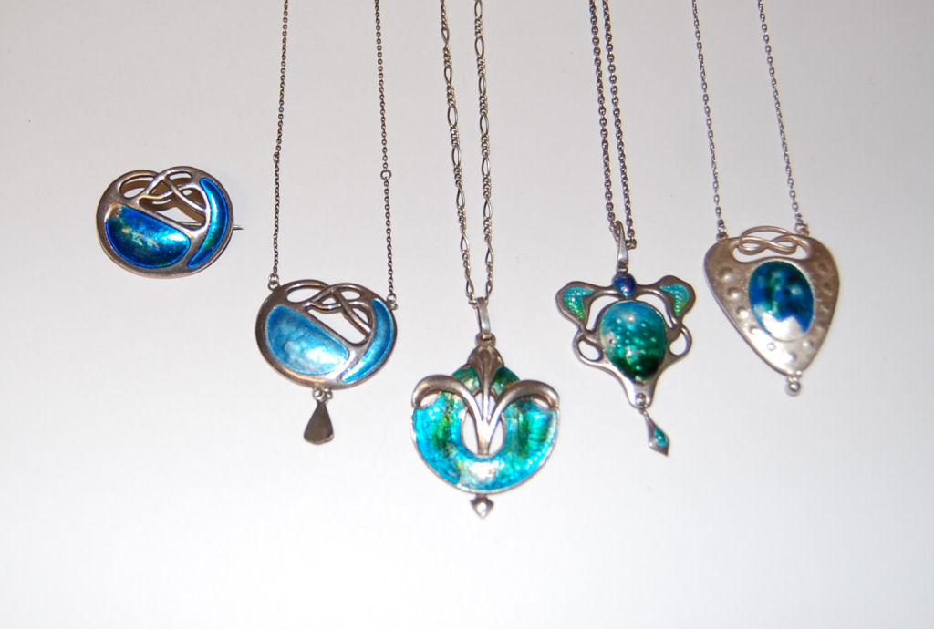 Four assorted enamelled necklaces and a matching brooch,
