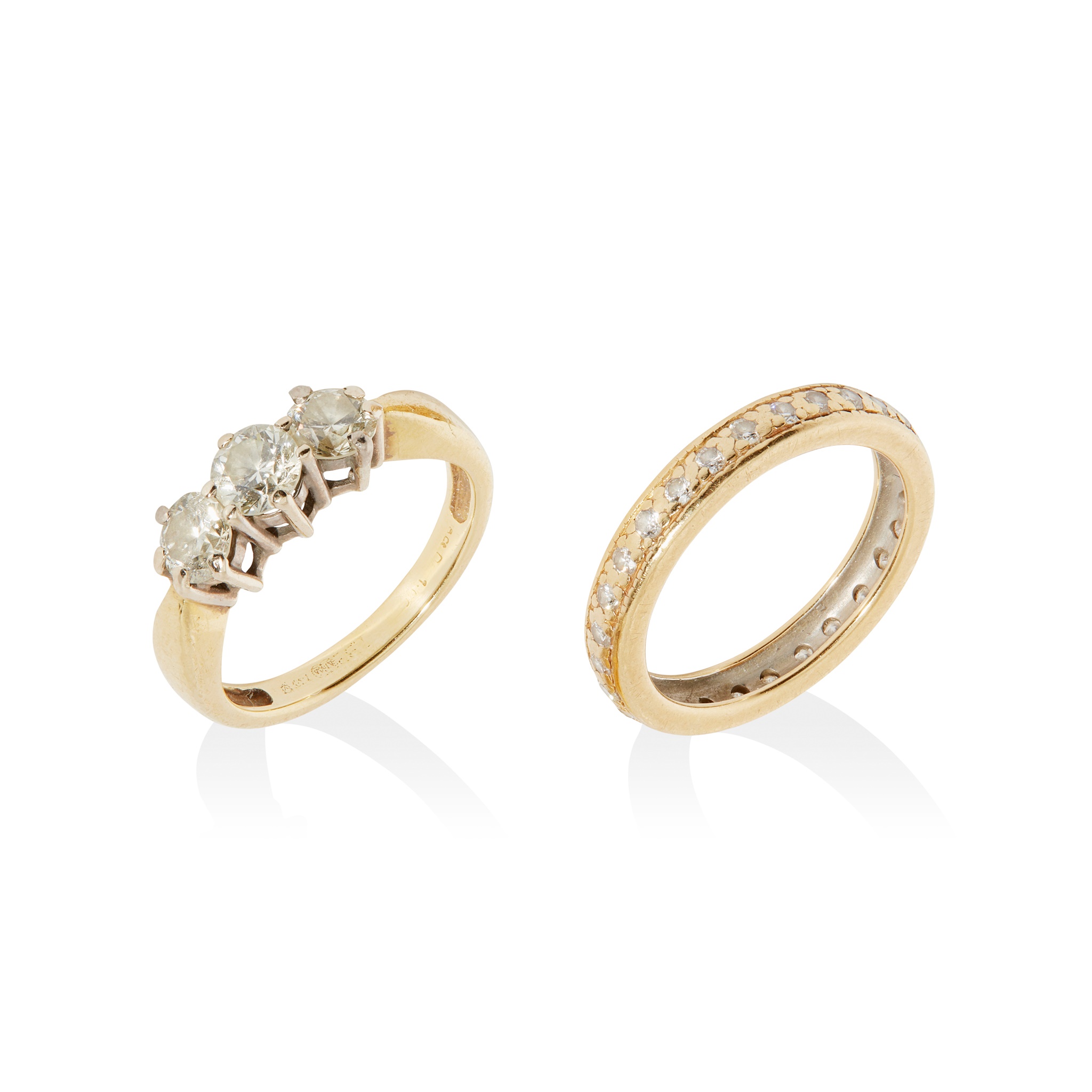 A three-stone diamond ring and plain band