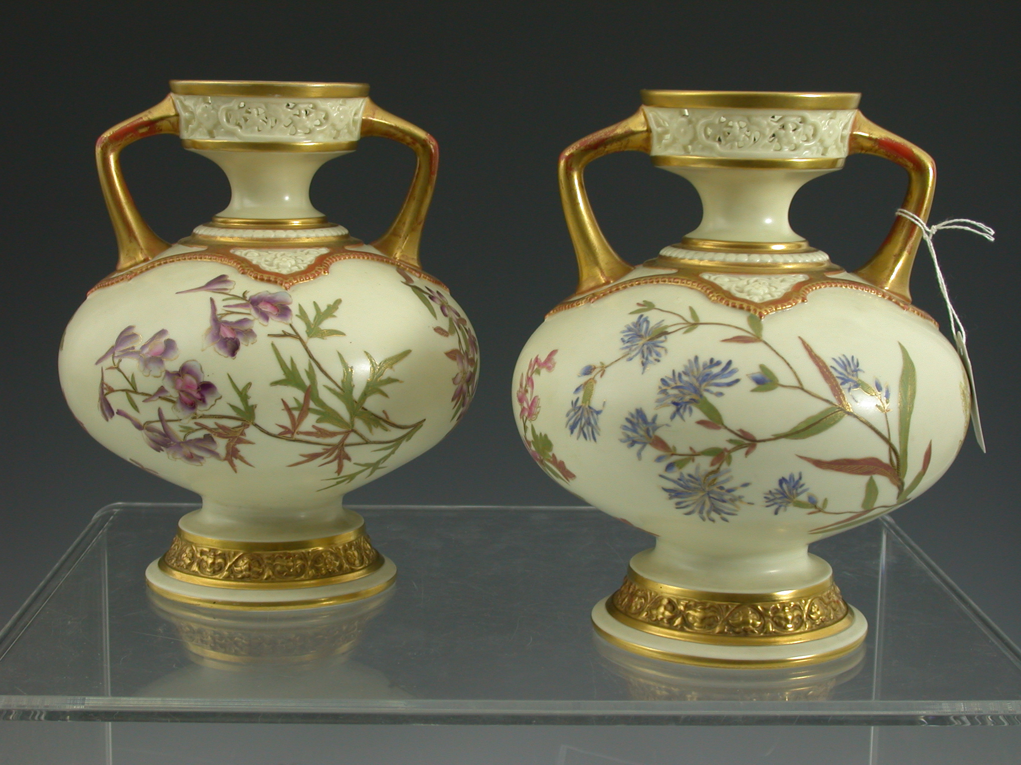 A pair of twin handled Royal Worcester baluster vases