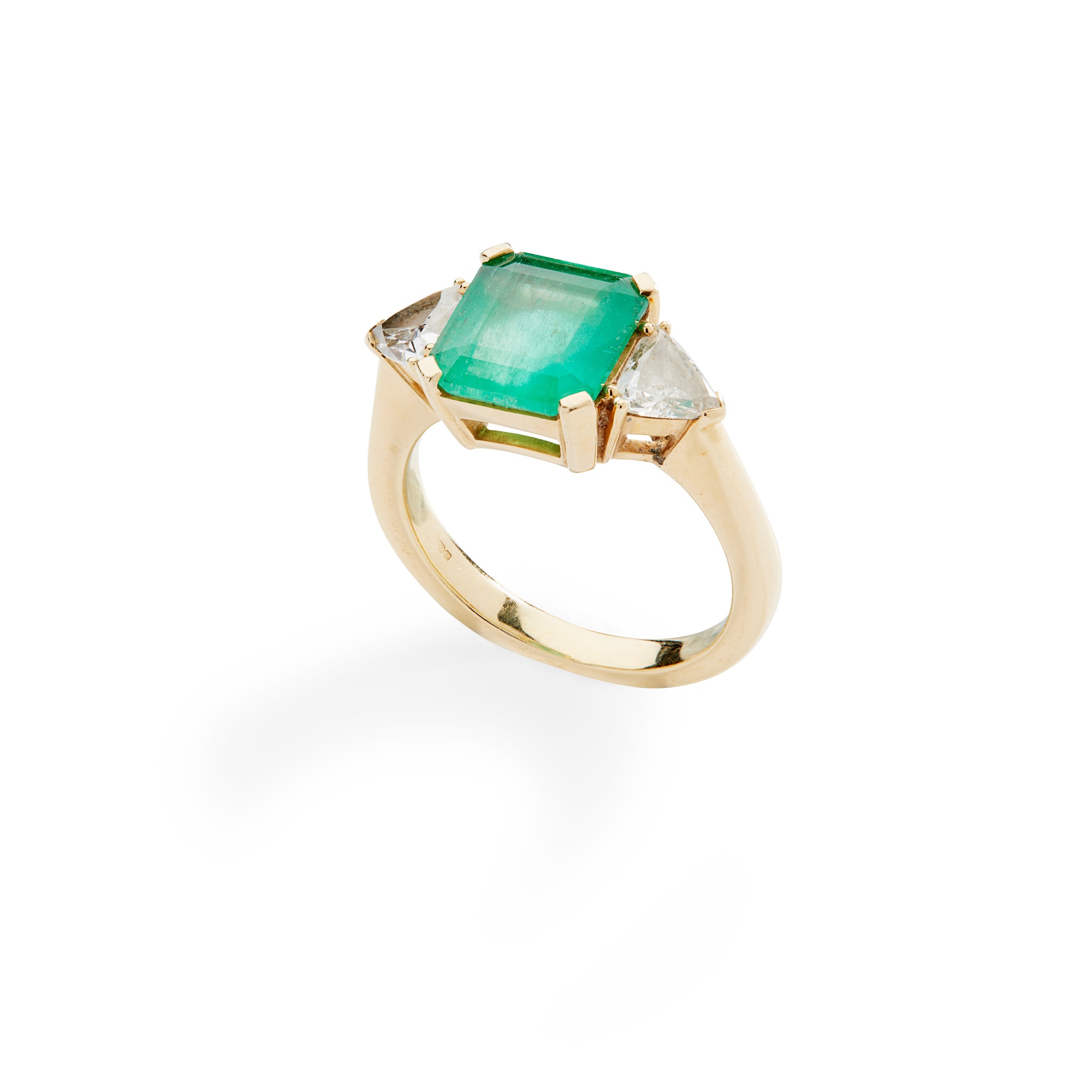 An emerald and diamond three-stone ring