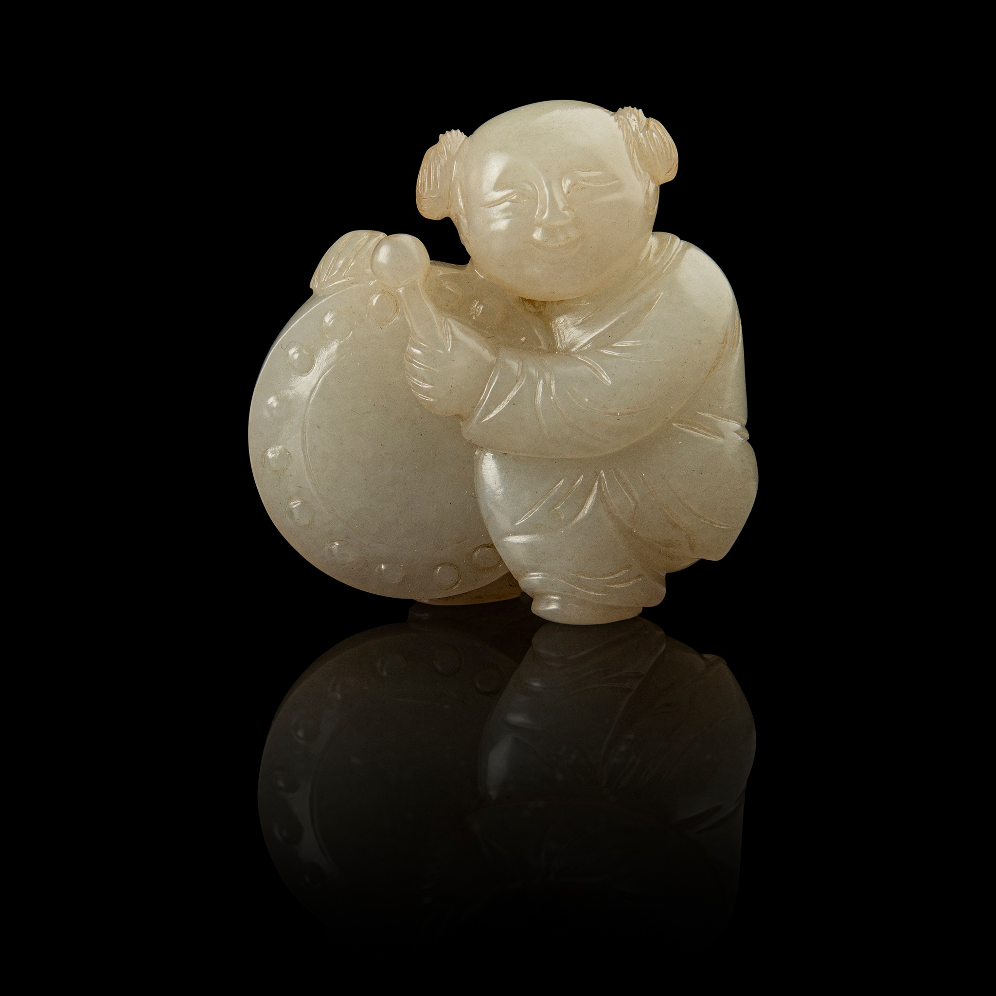 WHITE JADE CARVING OF A BOY PLAYING DRUM
