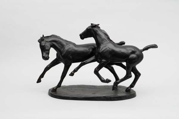 <p>A bronze sculpture of two galloping horses, with a dark patina. Signed.</p>