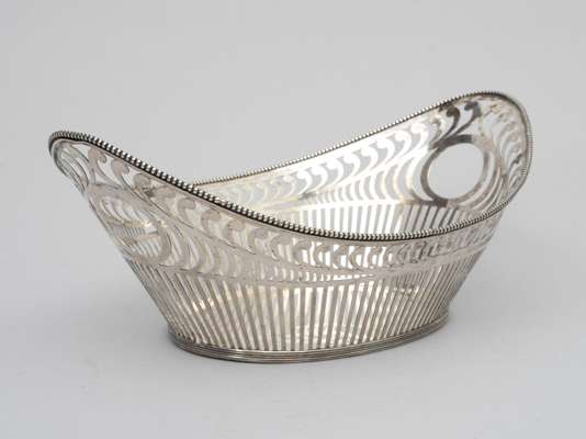 <p>De ajour bewerkt schuitvorm op ovale voet. De rand gedecoreerd met pareldecor. 2e gehalte (835/1000). Meesterteken AL. = Landmeter A. (1919/1925) Schoonhoven. Gewicht 385 gram.&nbsp;</p>