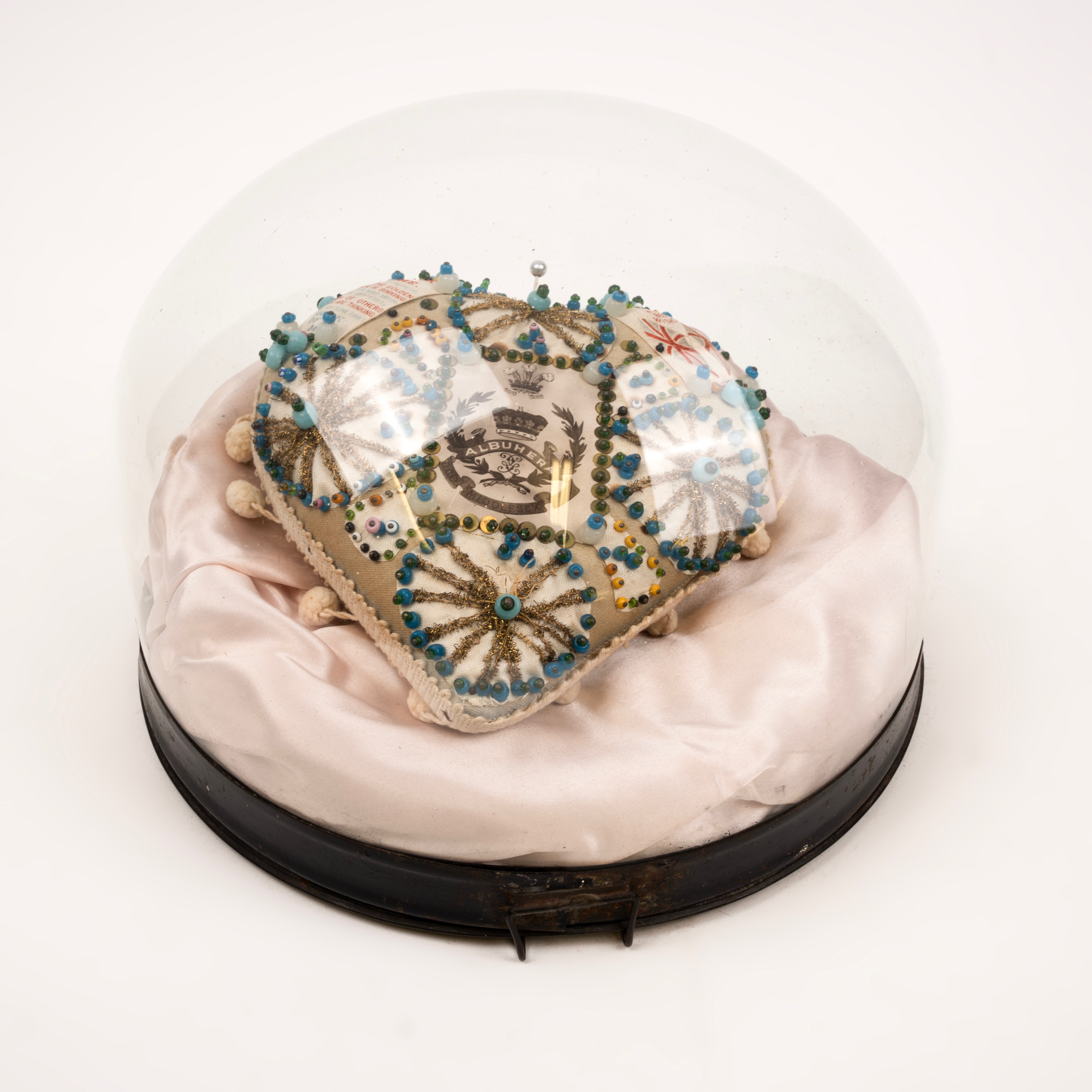 Middlesex needlework cushion in glass display