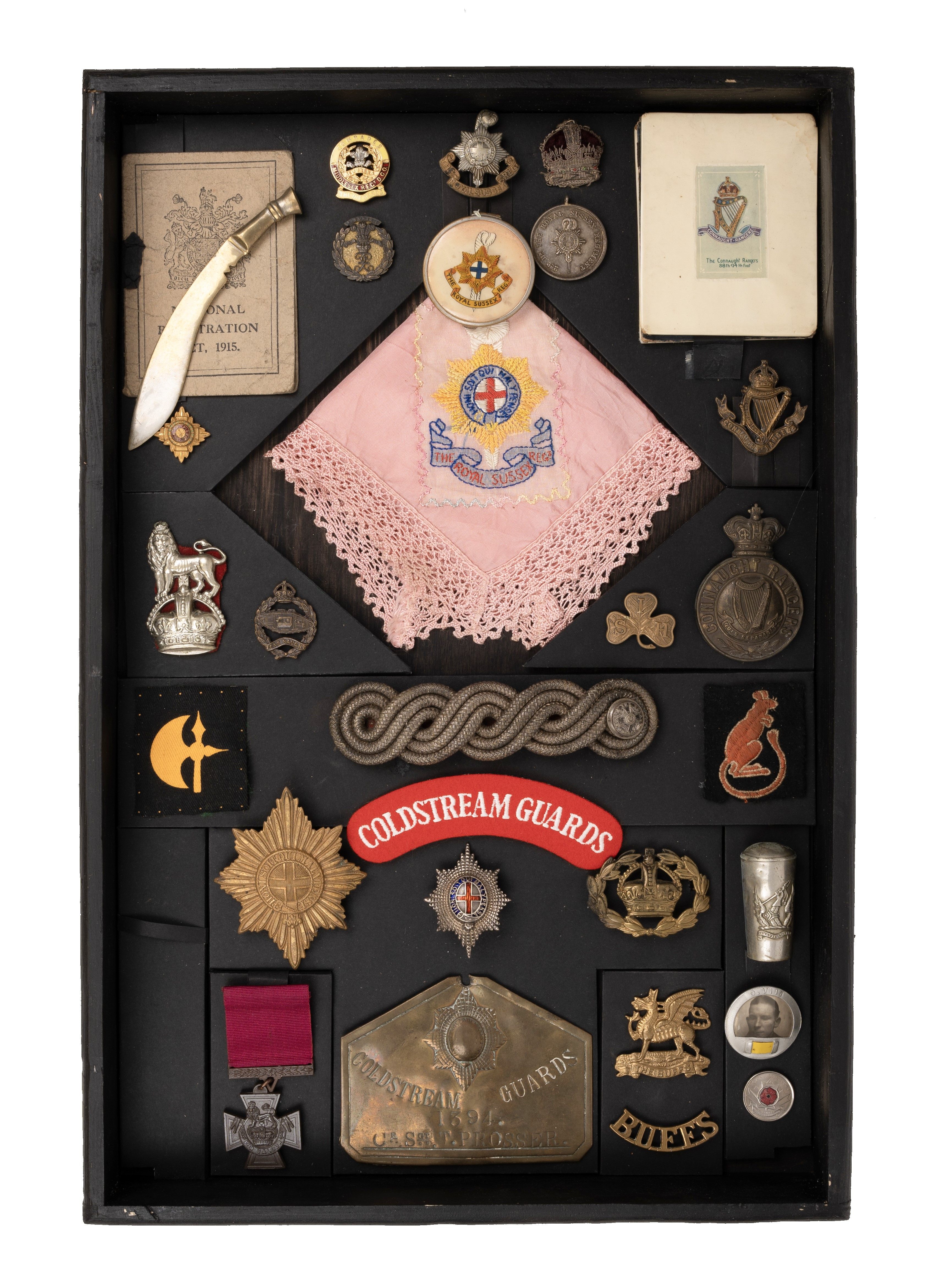 Collection of badges, including Coldstream Guards, Buffs, Royal Tank Regiment, items housed in display box