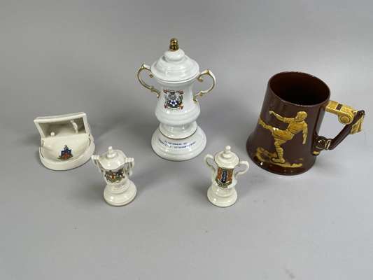 A crested Arcadian model of the FA Cup, another larger example by Blue Moor, a Dartmouth tankard decorated with a football scene and a crested pottery
