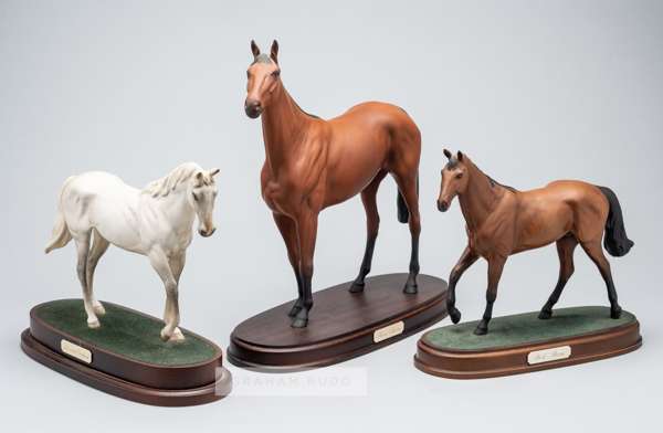 A trio of Royal Doulton models of champion steeplechase racehorses,
 two of thee triple Grand National winning racehorse Red Rum, both set on a wooden