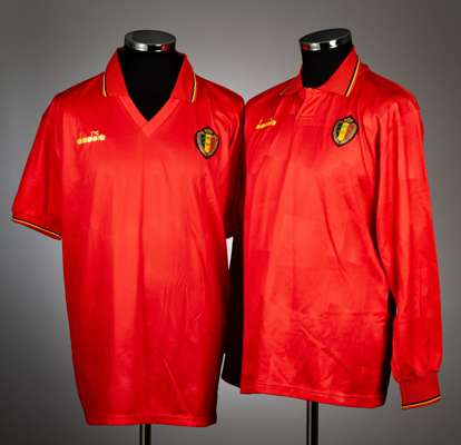 Two red Belgium international home jerseys, dating from the 1990s,
 both by Diadora, with yellow logo, yellow and black trim to wing collars, both wit