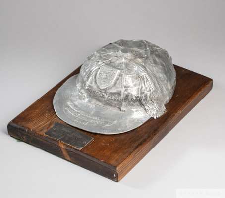 An unusual full size white-metal copy of Nobby Stiles's 1966 World Cup cap
 on hardwood plaque with card plaque inscribed Nobby Stiles, 1966 World Cup