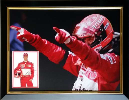 Michael Schumacher seven time F1 World Champion signed and framed display,
 measuring 69 by 55cm., features an official Ferrari sponsors postcard auto