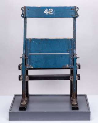 Old Wembley blue fold out seat complete with frame in a display case