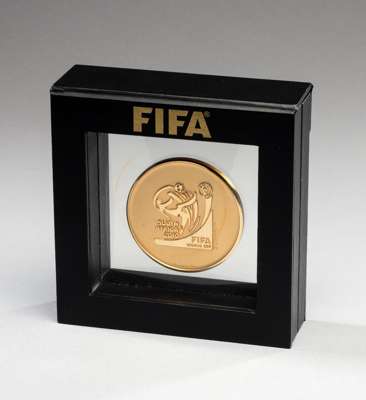 FIFA 2010 World Cup draw medal presented to Pel?, the design featuring the World Cup trophy on one side and the logo of the 2010 World Cup on the othe