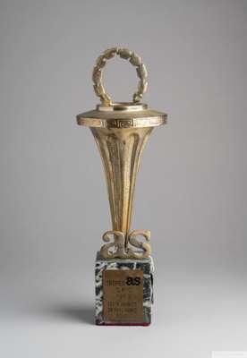 A gold tone base metal trophy given to Pelé by "AS" [Associazione Sportiva]
 torch topped with a laurel wreath is mounted on a marble base with letter