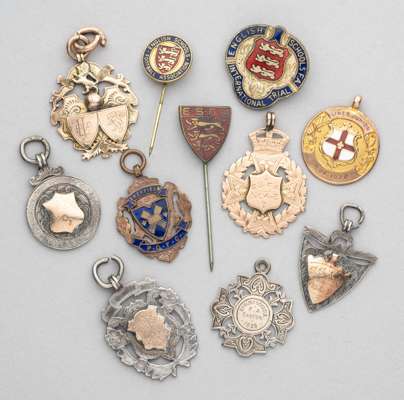 A collection of medals and badges relating to Schools and Junior football, 
 including three examples struck in 9ct gold, the first inscribed ESFA 190