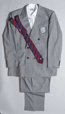 An official England Football Association Italia '90 two-piece grey suit,
 with embroidered three lion crest badge, size 41L, with maroon and blue offi