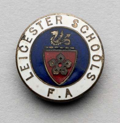 A Leicester Schools' F.A. badge awarded to the future professional footballer Eddie Clamp, 
 enamelled white metal complete with original fitting, min