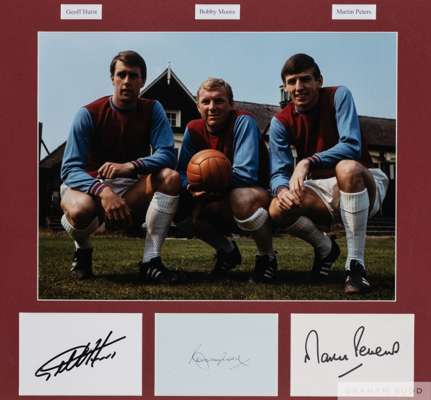 Photographic display signed by West Ham United's 1966 World Cup trio Bobby Moore, Geoff Hurst and Martin Peters,
 12 by 16in. colour photo portraying 