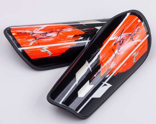 A pair of Lionel Messi autographed black and orange Adidas Messi Club shin pads