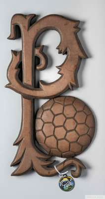 A trophy presented to Pelé composed of a wood letter "P" 
 next to a football, inscribed in ink on the verso "Zulinha e Galvão - Uberaba, M.G., 1980" 