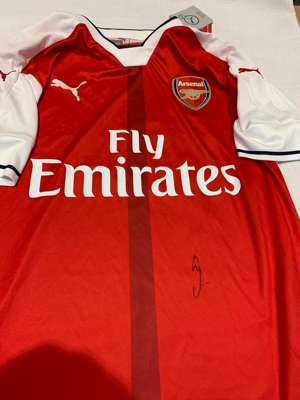 Mesut Ozil signed red and white Arsenal replica home jersey 2016-17,
 Puma, short-sleeved with club crest and sponsor logo, signed in marker pen to fr