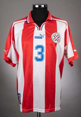Red and white Puma no.3 Paraguay International jersey from 2002,
 the jersey is a short sleeved red and white striped Puma example with blue trim. The