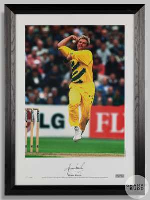 A large colour signed photographic print of Shane Warne bowling