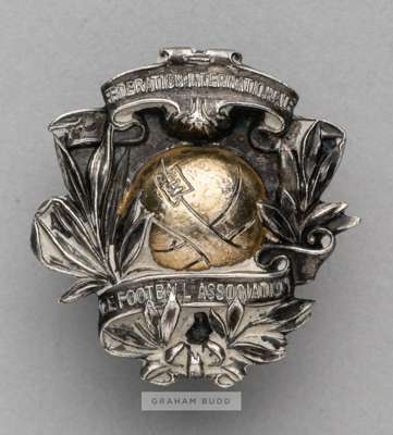 A rare and early FIFA badge circa 1911 originally belonging to the pioneering F.A. Official Charles James Hughes (1853-1916), 
 the white metal badge 