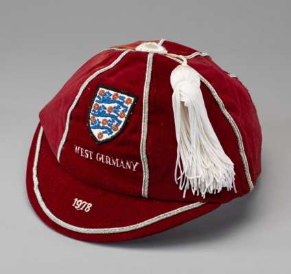 A red England v West Germany International Cap, 1978, 
 the red velvet cap with white tassel and silvered braiding, embroidered with the England three