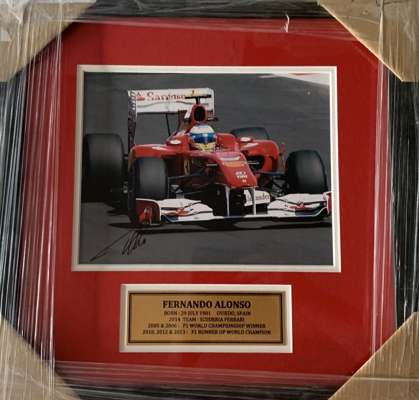 Fernado Alonso (Spain) signed Ferrari framed 8 by 10in. action photograph,
 professionally framed / glazed with double mattes and plaque. Frame Size: 