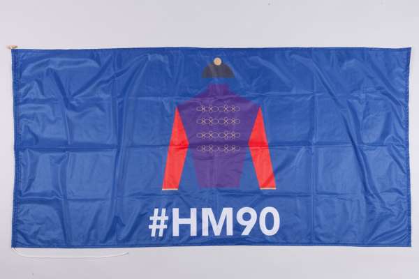 A flag marking HM The Queen's 90th birthday and featuring the Royal Racing Colours
