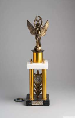 A trophy presented to Pelé on September 15, 1974. 
 The trophy is composed of a bronze, winged allegory holding aloft a wreath, mounted on a square of