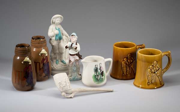 Collection of cricket ceramics 
 including two bisque figures of a 18th century boy holding a bat and ball, a clay pipe, Teachers Whisky water jug, a 