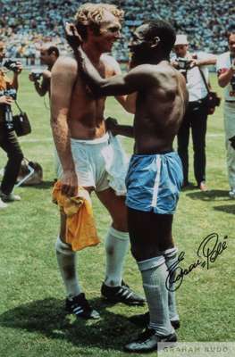 A large colour portrait photograph of the famous embrace between Pele and Bobby Moore at the 1970 Mexico World Cup Finals, 
 signed in black marker pe