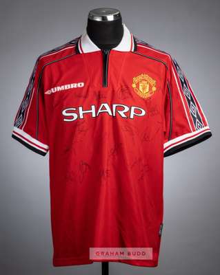 Manchester United red replica home jersey signed by the 1998-99 Treble winning squad,
 embroidered with club crest and Umbro logo, signed to the front