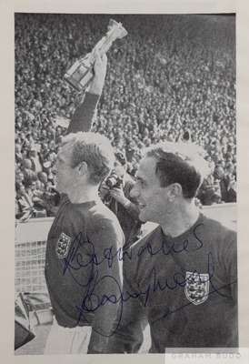Bobby Moore signed b&w picture holding the Jules Rimet trophy aloft parading around Wembley Stadium after England defeat West Germany 4-2 (aet) in the