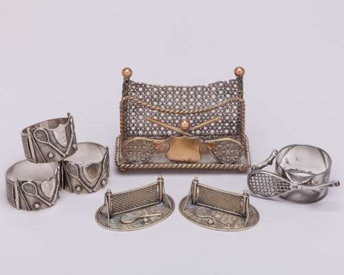 Three white-metal tennis napkin rings, each decorated with two rackets, two balls