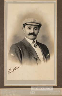 Signed b&w photograph of portrait of cricketer K.S. Ranjitsinhji,
 posed in a studio setting wearing a cap, jacket and tie. Signed lower left, mounted